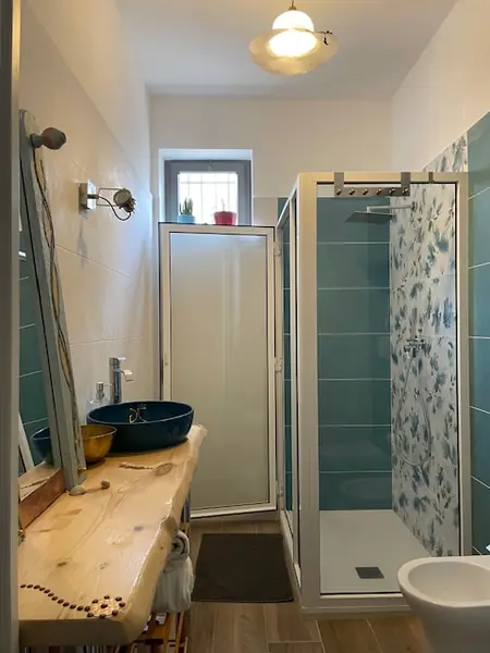 Bagno con finestra del bilocale Natura con lavabo artistico in legno