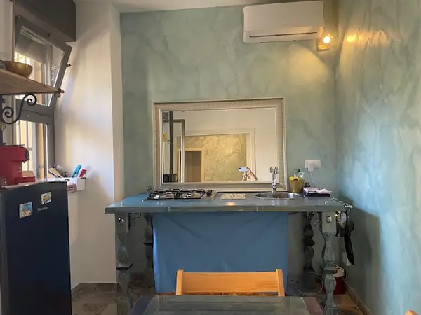 Cucina del bilocale Sicilia con pareti color petrolio